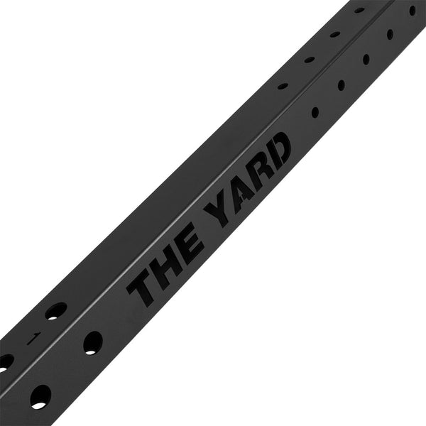 The SMAI The Yard - Rig - 10 Squat Cell is a black metal beam with evenly spaced holes and "THE YARD" cut out along its side, ideal for use in a Yard Gym or as a commercial gym solution.