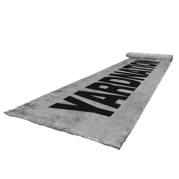 A low-angle view shows the SMAI The Yard - Grey YARDNATION Sled Turf Track (2m x 16m) with "YARDIMATIK" in bold black letters—perfect for those seeking a sleek alternative to standard turf flooring.