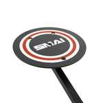 The X-Frame - Wall Ball Target, featuring concentric red and white circles on a round black pad labeled "SMAI," is mounted on a powder-coated upward-angled stand, ideal for commercial spaces.