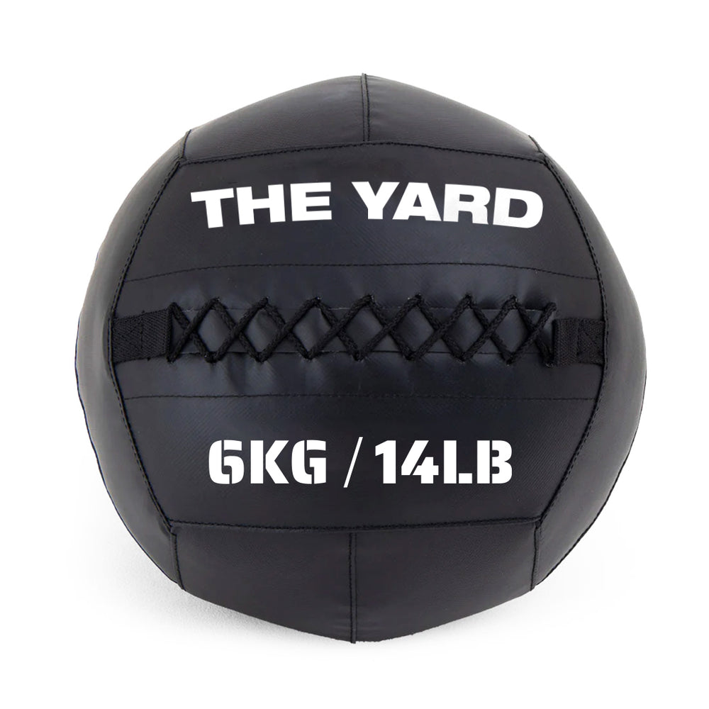 The Yard - Wall Ball 6kg by SMAI is a black gym ball with visible stitching, featuring "THE YARD" at the top and "6KG / 14LB" in bold white text on the front.