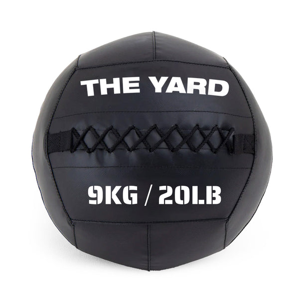 The SMAI The Yard - Wall Ball 9kg is a black wall ball made from recycled rubber, with "THE YARD" on top and "9KG / 20LB" below, visible stitching across the middle—ideal for your gym fitness routine.