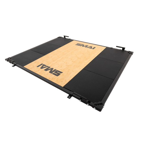 The SMAI Weight Lifting Platform - Black features a sturdy black metal frame, a wooden center with the SMAI logo, and surrounding black rubber—perfect for barbell weight training.