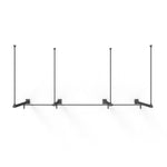 The Wall Mounted Rig - 2 Squat Cell with Bridge - X-Frame by No Sync To Channel Engine is a minimalist shelving unit made of black steel tubing. It features a modular design with three support brackets, mounted on a white wall. This product includes four vertical bars connected to a horizontal bar, making it ideal for displaying items.