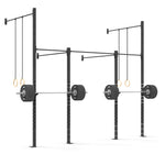 A gym setup includes the Wall Mounted Rig - 2 Squat Cell with Bridge - X-Frame, which features two parallel steel racks, each supporting a barbell with weights. Gymnastic rings are suspended from bars above the racks. This commercial equipment, supplied by No Sync To Channel Engine, is arranged against a plain white background to highlight its modular design for versatile workouts.