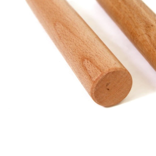 Close-up of two SMAI Wooden Pegs (Pair) positioned parallel on a white background, highlighting their sleek, cylindrical form and natural wood grain texture, ideal for climbing boards.