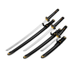 The SMAI Daisho - Carbon 3pc Set with Stand - Shi no Tora features three collectible samurai swords with black and gold handles, matching scabbards, and ornate gold detailing for a striking display.