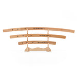 The SMAI Shirasaya 3pc Sword & Stand features three minimalist wooden Japanese swords of varying lengths with black kanji, displayed horizontally on a wooden stand against a white background.