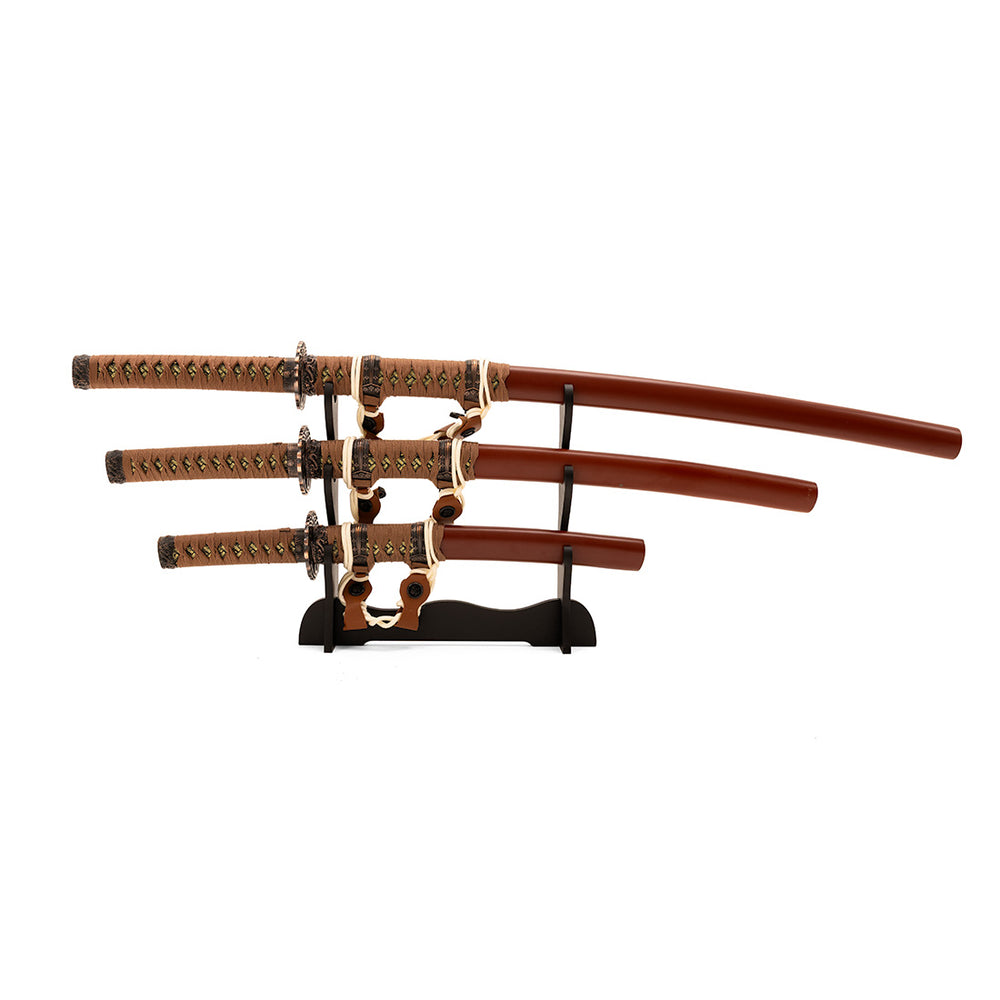 The SMAI Samurai 3pc Sword & Stand - Brown set includes a katana, wakizashi, and tanto with ornate handles and brown sheaths, beautifully displayed on a black wooden stand against a white background.