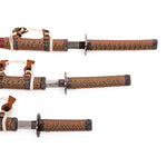 The SMAI Samurai 3pc Sword & Stand - Brown set features katana, wakizashi, and tanto swords with brown and green-wrapped handles and ornate hilts, elegantly displayed on a white background.
