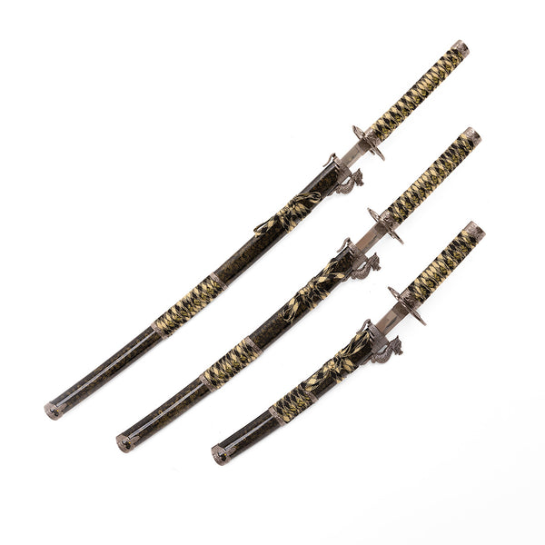 The SMAI Daisho - 3pc Set with Stand - Desert Dragon features three decorative Japanese swords with black and gold handles and matching scabbards, displayed diagonally on a white background. Blade lengths vary for an elegant display.