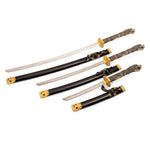 The Daisho - Highlander Display by SMAI features three Japanese swords—katana, wakizashi, and tanto—with black scabbards and gold-accented hilts, elegantly displayed side by side on a white background.