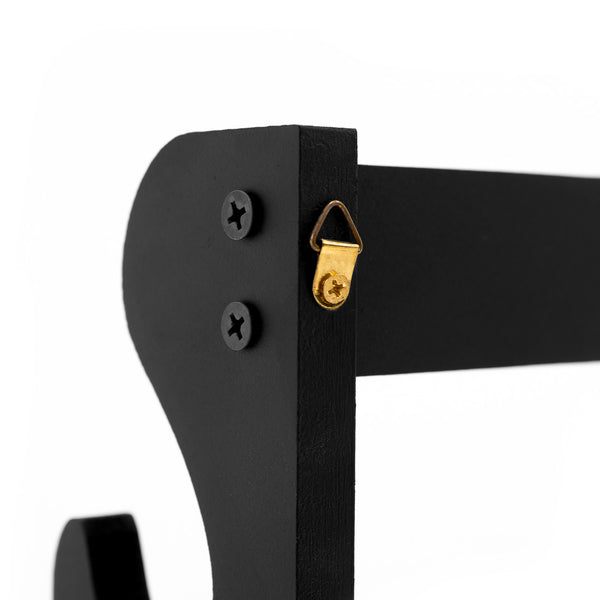 Close-up of the corner of the SMAI Double Sword Display Wall Mounted, in black wood, attached to the wall with two black screws and a small gold triangle hanger on the side, shown against a white background.