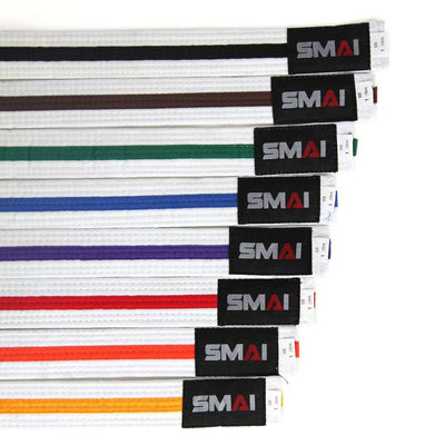 A diagonal display of SMAI's Martial Arts Belt - Coloured Stripe in poly-cotton features vibrant, color-fast belts with a black tag reading "SMAI" in white and red, available in white, yellow, orange, green, blue, purple, brown, black, and red.