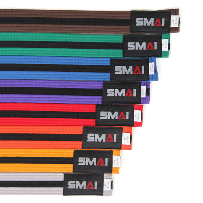 A diagonally arranged row of SMAI Martial Arts belts for Karate enthusiasts showcases various colors: white, yellow, orange, green, blue, purple, brown, red, and black. Each belt features a "SMAI" label on the end.