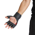 A person wearing the SMAI Elite85 MMA Gloves - Black, crafted from cowhide leather with a fingerless, open-palm design and bent fingers to showcase the glove’s features. The arm is pictured from the elbow down against a white background.