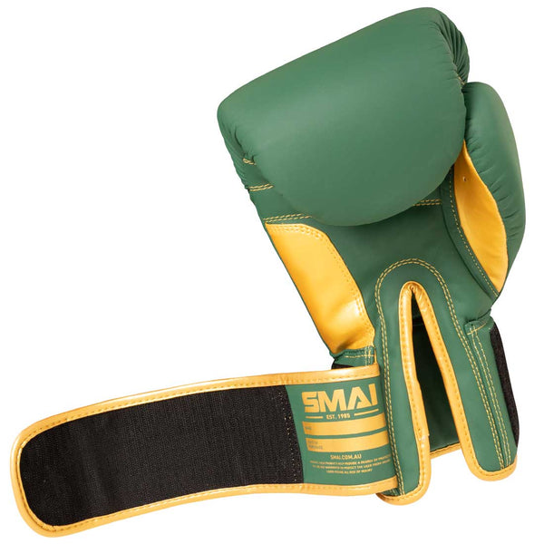 The Gold Series Boxing Glove - Green/Gold by SMAI features a green and gold design with a black and gold wrist strap, displaying the palm side and the "SMAI" branding on the wrist area. It is designed to provide excellent wrist support for enhanced comfort during training.