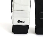 A close-up of a black and white martial arts foot protector featuring the "SMAI" logo. Crafted with EVA foam padding and an ergonomic design, it ensures a secure fit with its adjustable strap. The plain white background highlights its sleek, professional look.