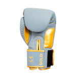 The SMAI Gold Series Boxing Glove in light blue with gold accents features detailed gold stitching, a Velcro strap closure, and the word "GOLD" printed near the wrist. Designed for superior wrist support and shock protection, these boxing gloves are presented against a plain white background.