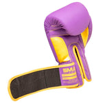 The SMAI Gold Series Boxing Glove - Purple/Gold features a long open strap with visible velcro, bold stitching, and prominent branding on the wrist area, delivering enhanced wrist support for safer training sessions.