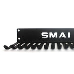 Introducing the Skipping Rope - Storage Solution by SMAI, a sleek black wall-mounted rack adorned with a laser-cut design and pegs, featuring the brand's name elegantly displayed in white lettering—ideal for organizing your skip ropes.