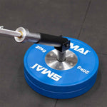 The SMAI The Yard - Drop In Landmine / Core Trainer fits into a 20kg blue weight plate on the gym floor, securing a barbell for rotational and pressing exercises—ideal for effective core barbell workouts.