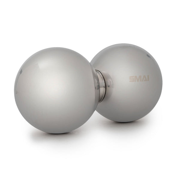 The Peanut Roller Pack by SMAI features a pair of silver metal juggling balls connected at the center, shimmering softly on a white background. This product combines visual appeal with the potential for soothing massage or pain relief.