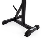 Close-up of a black and red metal, freestanding squat stand featuring a sturdy base and angled support bars for enhanced stability. The brand "Sale Item" is printed in white on the lower crossbar. The background is plain white.