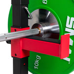 Close-up of a weightlifting setup featuring the Sale Item Portable Squat Stand - Red / Black (Pair), a barbell with a knurled grip resting on it. A 10 kg green weight plate is attached and secured with a metal pin, complementing the bold red and black design.