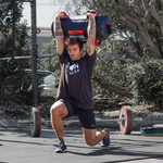 Man holding 25kg SMAI Core Bag above his head while lunging