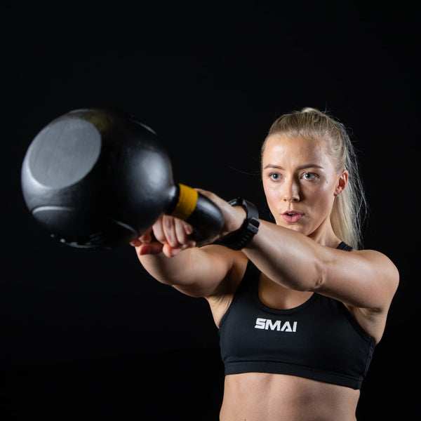 woman lifting Cast Iron Kettlebells SMAI black 4