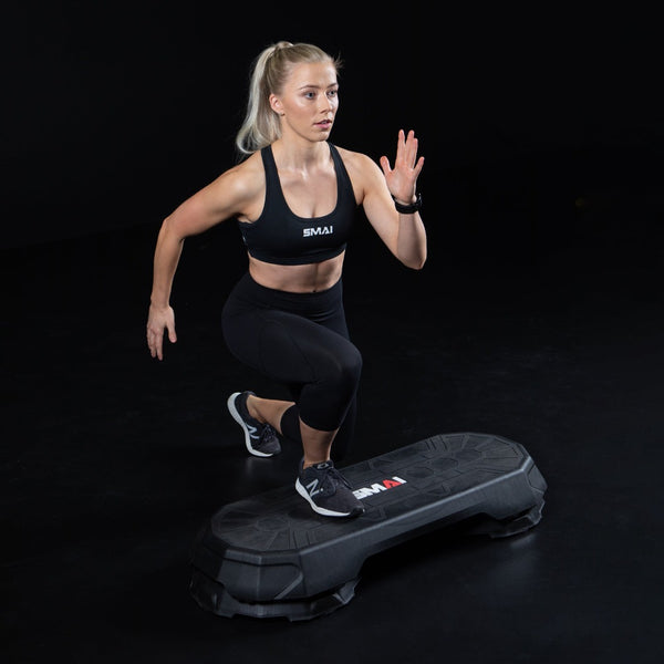 Woman using SMAI Aerobic Stepper black with risers 