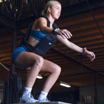 Woman jumping on a plyometric box with a  SMAI weight vest adjustable